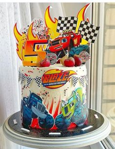 a birthday cake decorated with cars and flames