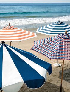 several beach umbrellas are lined up on the beach