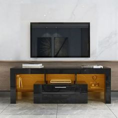 an entertainment center with a flat screen tv mounted on it's sideboard in a living room