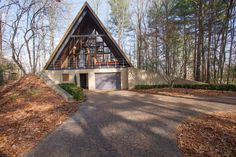 a house in the woods with a walkway leading to it's entrance and garage