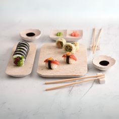 sushi and chopsticks on a white table with marble counter top, including two plates