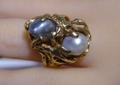 Vintage 14k Yellow Solid Gold Nugget Ring W/ Genuine 2 Pearls Looks like people Hugging ring weights 14.6 grams size 7 1/2 Ring is 15/16" wide almost 1" wide north to south.     YOU ARE BIDDING OR BUYING ON A GORGEOUS, 100% GUARANTEED AUTHENTIC PIECE OF JEWELRY.      ALL OUR ITEMS, JEWELRY AND STONES ARE TESTED AND GUARANTEED. WE DO NOT OFFER ANY WARRANTIES, ALL ITEMS ARE SOLD AS IS.    DO NOT MISS THIS OPPORTUNITY TO PURCHASE A UNIQUE PIECE OF JEWELRY AT A GREAT PRICE! FEEL FREE TO CONTACT US IF YOU HAVE ANY QUESTIONS OR WOULD LIKE ANY ADDITIONAL PHOTOS! *PLEASE NOTE: ALL OUR PICTURES ARE TAKEN OF THE ACTUAL ITEM YOU WILL RECEIVE* PAYMENT IS EXPECTED WITHIN 48 HOURS OF CLOSE OF AUCTION OR SALE.   -ALL DOMESTIC ORDERS ARE FULLY INSURED AND SHIPPED VIA USPS. INTERNATIONAL SHIPPING Only with Heirloom High Luster Ring Jewelry, Heirloom High Luster Ring, Heirloom Jewelry With High Luster For Anniversary, Unique High Luster Jewelry For Formal Occasions, Unique High Luster Jewelry For Anniversary, Gold Nugget Ring, People Hugging, Gold Nugget, Large Ring