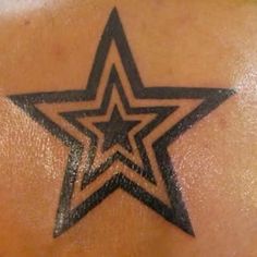 a star tattoo on the back of a woman's upper arm and shoulder area