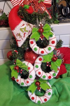 a christmas tree with stockings and ornaments on it's top, sitting in front of a kitchen counter