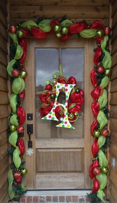 the front door decorated for christmas with decorations on it and a number hanging from the side