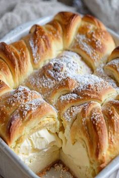 a pan filled with rolls covered in powdered sugar