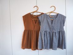 two dresses hanging on a clothes rack