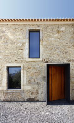 a stone building with two windows and a wooden door