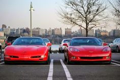 two red sports cars parked in a parking lot