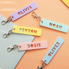 three name tags are attached to each other on a keychain with two pairs of scissors