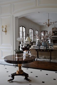 a living room filled with lots of furniture next to a fire place and chandelier