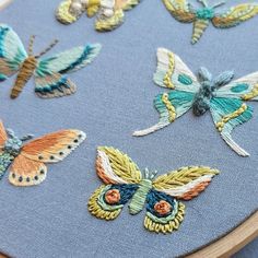 a close up of a cross stitch project with butterflies on the back and in the middle