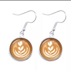 pair of earrings with latte art in the shape of a leaf on white background