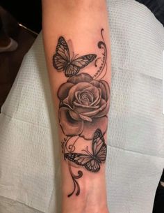 a rose and butterflies tattoo on the arm