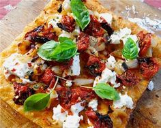 a square pizza topped with tomatoes, cheese and basil