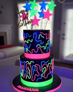 a three tiered cake decorated with neon stars