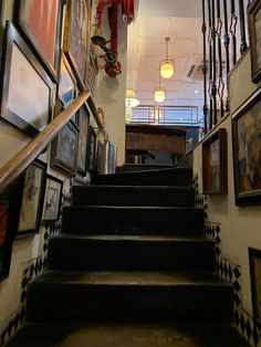 the stairs are lined with pictures and framed photographs