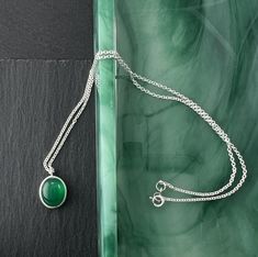 This rich green gemstone pendant is bezel set on a cable chain. Onyx is in the chalcedony family and this gemstone has been dyed to this deep, lovely green. Size: - Pendant length is 17mm, 5/8" - Pendant width is 12mm, 1/5' - Gemstone is 12 x 10 millimeters - Chain length 16" - Chain width is 1.7 millimeters - Weight is 5.1 grams Handmade: This pendant is handmade with a genuine gemstone and nickel free sterling silver. Processing Time: Usually, I can ship this item out within 2 days from the or Onyx Pendant, Gemstone Pendant Necklace, Rich Green, Onyx Gemstone, Women's Jewelry And Accessories, Silver Jewelry Handmade, Gemstone Necklace Pendant, Green Gemstones, Green Onyx