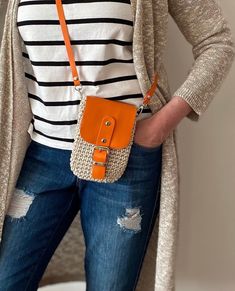 a woman is holding an orange purse