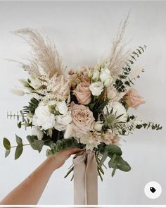 someone holding a bouquet of flowers in their hand