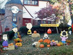 a house decorated for halloween with pumpkins, hay bales and peanuts on the lawn