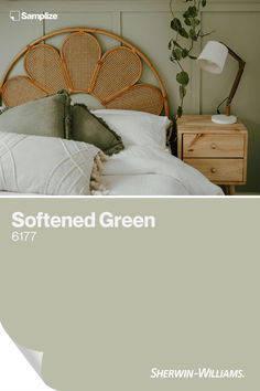 a bed with white sheets and green pillows