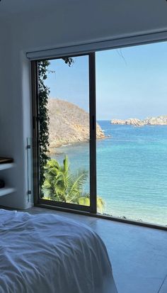 a bedroom with a large window overlooking the ocean