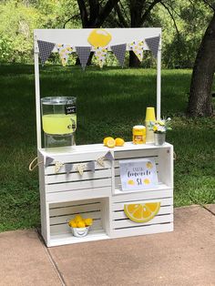 an outdoor lemonade stand is set up in the grass