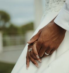 a close up of a person holding the hand of another person's wedding dress