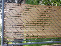 a close up of a metal fence with wood slats on the top and bottom