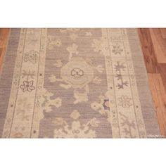 an old rug with many different designs on the carpet and wood flooring in front of it