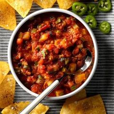 a white bowl filled with salsa surrounded by tortilla chips