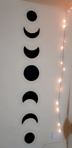 there are three circles on the wall with string lights around it and one circle has five faces