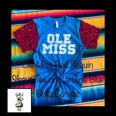 University of Mississippi OLE MISS Red Sequin Sleeve Tee Shirt on Carolina Blue Bella Canvas Tee Red T-shirt For School Spirit In Fall, Red Fan Apparel T-shirt For Fall, Red Summer Game Day Tops, Red School Spirit Tops For Fall, Red Tops With School Spirit For Fall, Red Tops For Fall School Spirit, Blue Fitted Tops For College, Red T-shirt For Fall Game Day, Red T-shirt For College Summer Events