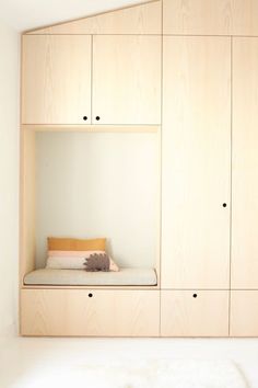 there is a small bed in the corner of this room with built - in cupboards