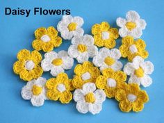 crocheted daisy flowers on a blue background with the words daisy flowers written in white and yellow