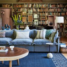 a living room filled with lots of furniture and bookshelves full of books on shelves