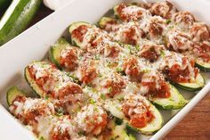 stuffed zucchini boats with meat and sauce in a white casserole dish