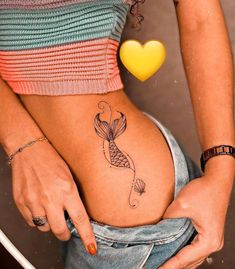 a woman with a fish tattoo on her stomach is holding onto the side of her belly