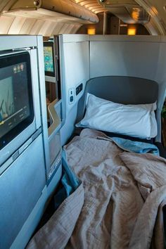 the inside of an airplane with a bed and television