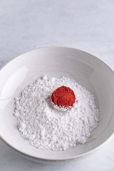 a white bowl with red powder in it