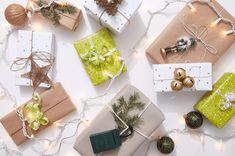 presents wrapped in brown paper and tied with twine, surrounded by christmas lights on white background