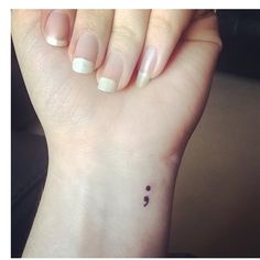 a woman's hand with a small tattoo on it