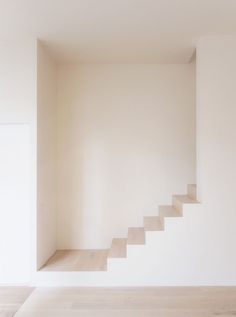 an empty room with white walls and stairs