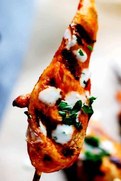 a close up of a chicken skewer with cheese and spinach on it