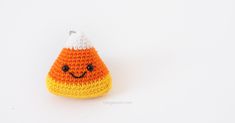 a crocheted orange and white candy cornucopie with a smiley face