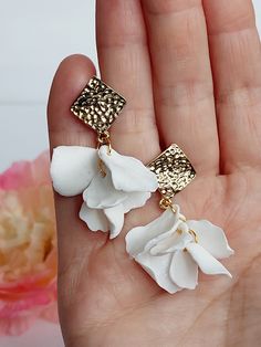 https://purplebeestudio.etsy.com Handmade unique polymer clay white rose petal earrings. The flower petals are handmade by me from polymer clay without using any molds. These very elegant delicate lightweight earrings will become your favorits for many occasions. Earrings made with brass ear studs. The earrings are very light and comfortable to wear all day. SHIPPING: Your order will be dispatched in a securely packed cardboard box. Product care:  - To ensure the product quality and durablility, avoid contact with water, lotion, perfumes and household cleaners and chemicals. - You can clean the products with a slightly damp soft fabric.  - Sharp objects can damage the clay surface. - When not in use, store in a dry, seperate box. Thank you for visiting my shop! If you have any special requ Flower Petal Earrings, Bridal Party Earrings, White Hoop Earrings, Polymer Clay Flower Jewelry, Petal Earrings, Dangle Earrings Wedding, Floral Jewelry, Earrings Bridesmaid, Handmade Gifts For Her