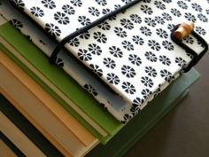 several books stacked on top of each other with a black and white flowered cover