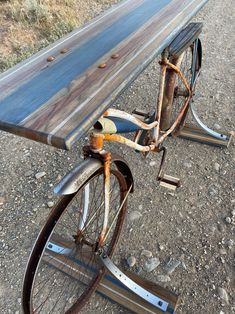 an old bicycle is parked next to a wooden bench