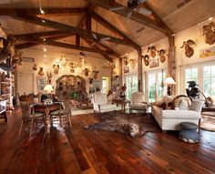 a living room filled with furniture and lots of deer antlers on the wall above it